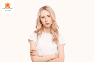 Eine Frau mit verschränkten Armen und den Worten „Warum bin ich so traurig?“.